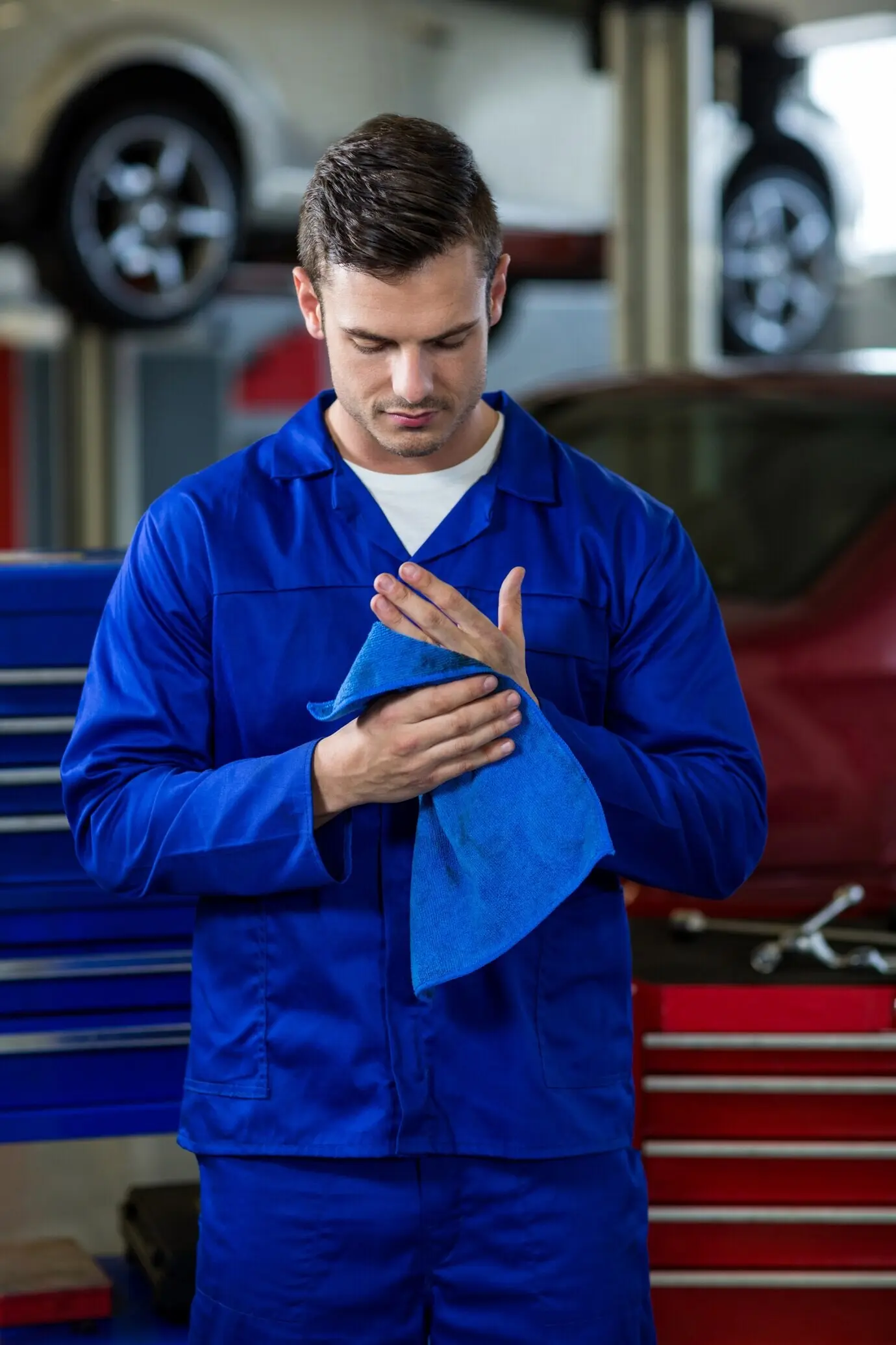 Mechaniker, der sich die Hände mit einem Reinigungstuch abwischt.